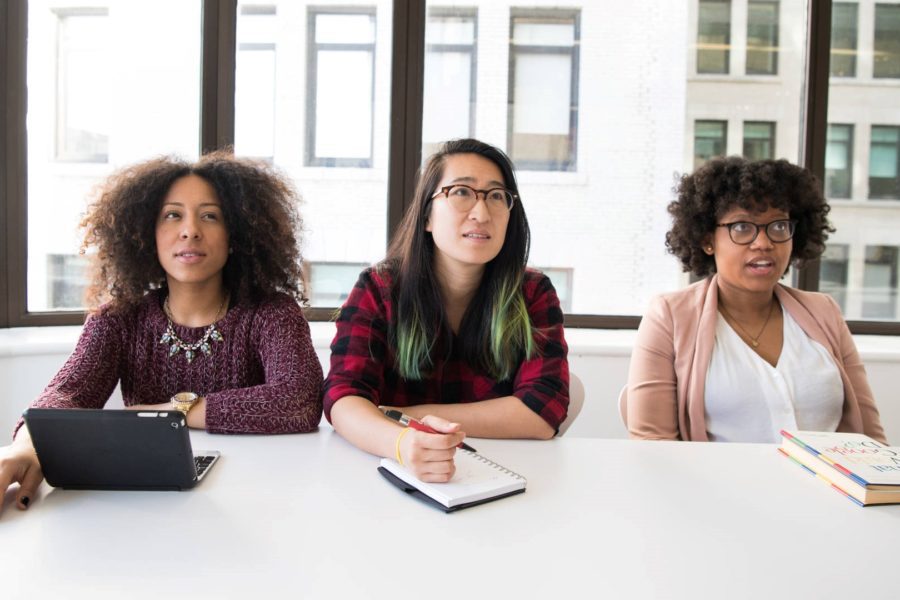 Three confused employees look on at business meeting