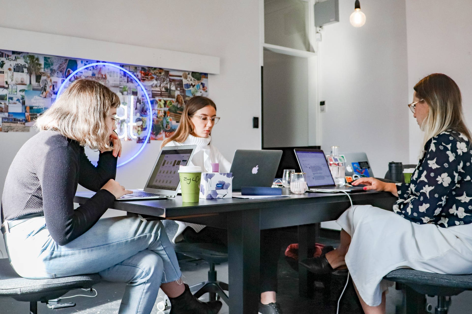 Three young woman at a table discussing start-up business