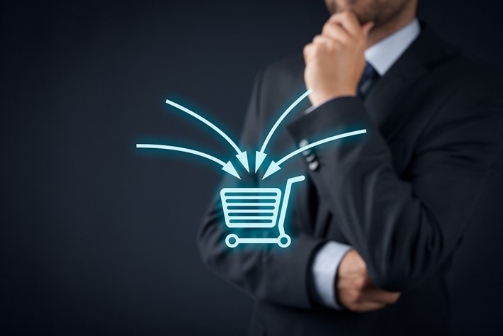 Businessman-out-of-focus-behind-blue-neon-shopping-cart-icon