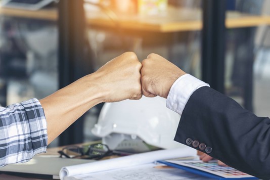 Business partners fist bumping
