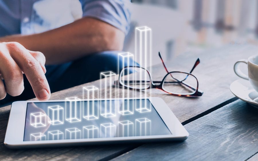 Businessman analyzing growing 3D AR chart floating above digital tablet computer screen, showing successful increase in business profit
