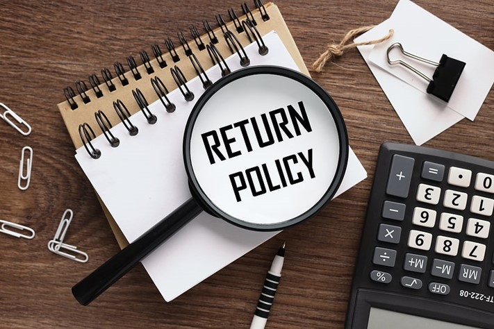 “return policy” printed on notebook, under a magnifying glass
