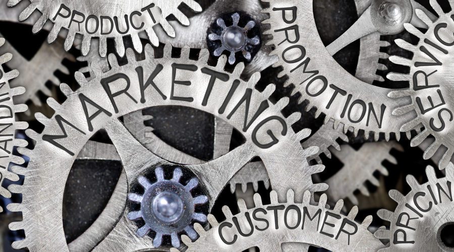Macro photo of tooth wheel mechanism with MARKETING, CUSTOMER, PROMOTION, SERVICE, PRICING, PRODUCT and BRANDING words imprinted on metal surface